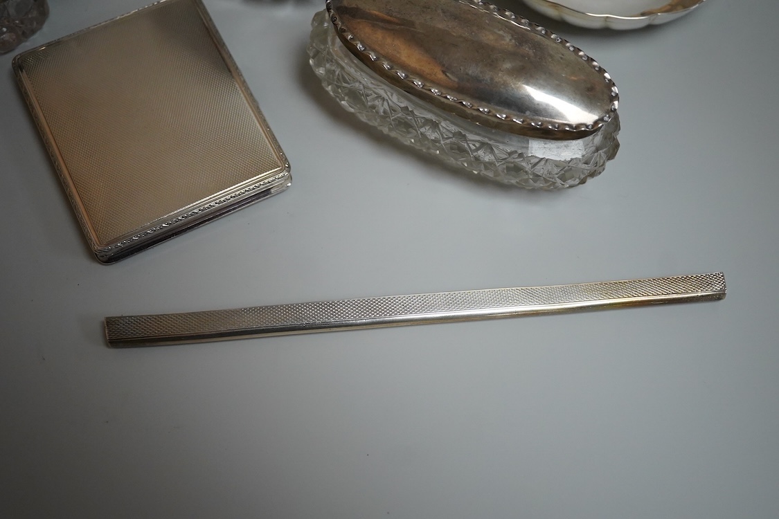 An 835 standard engine turned white metal powder compact, 72mm, three silver mounted glass toilet jars, two silver mounts and an Italian 800 standard small dish.